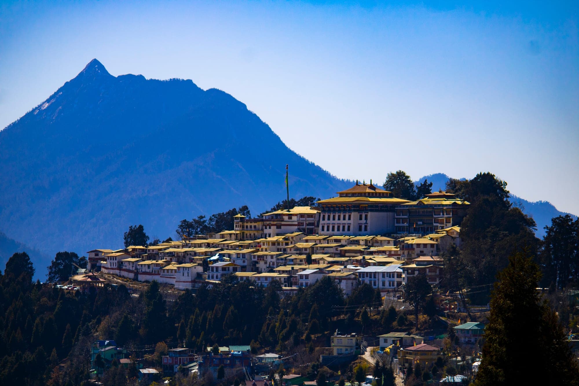 Tawang Monastery on its hilltop below a sharp Himalayan peak in Arunachal Pradesh