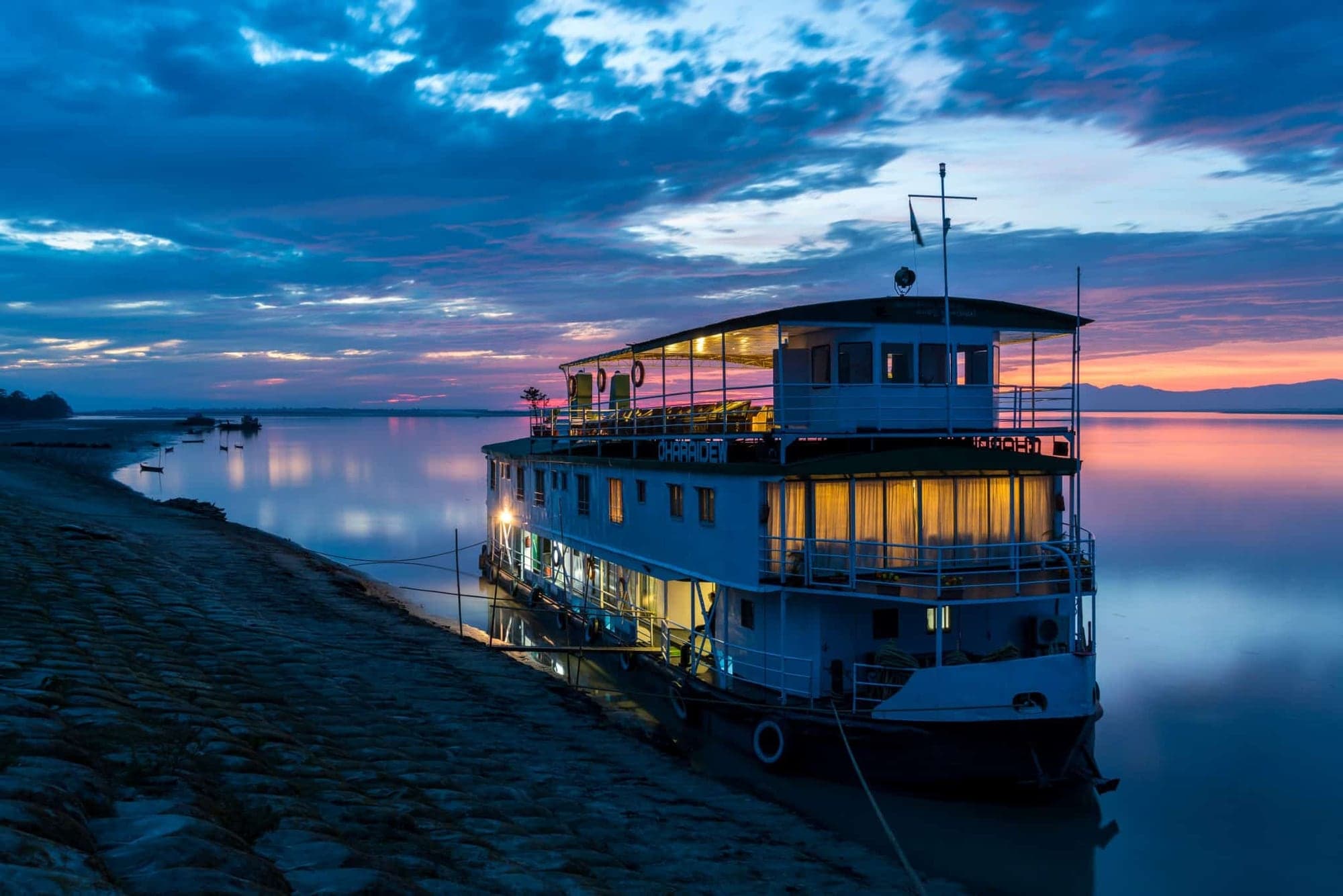 A riverboat lit up at dusk on the Brahmaputra in Assam