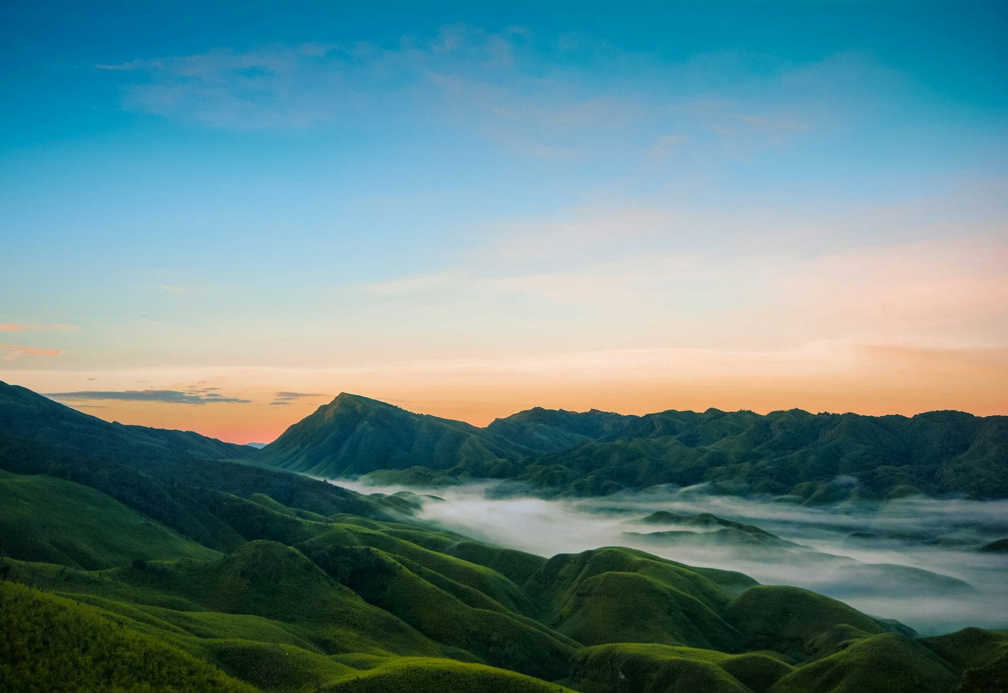 Sunrise over the green hills and mist of Dzükou Valley near Kohima, Nagaland